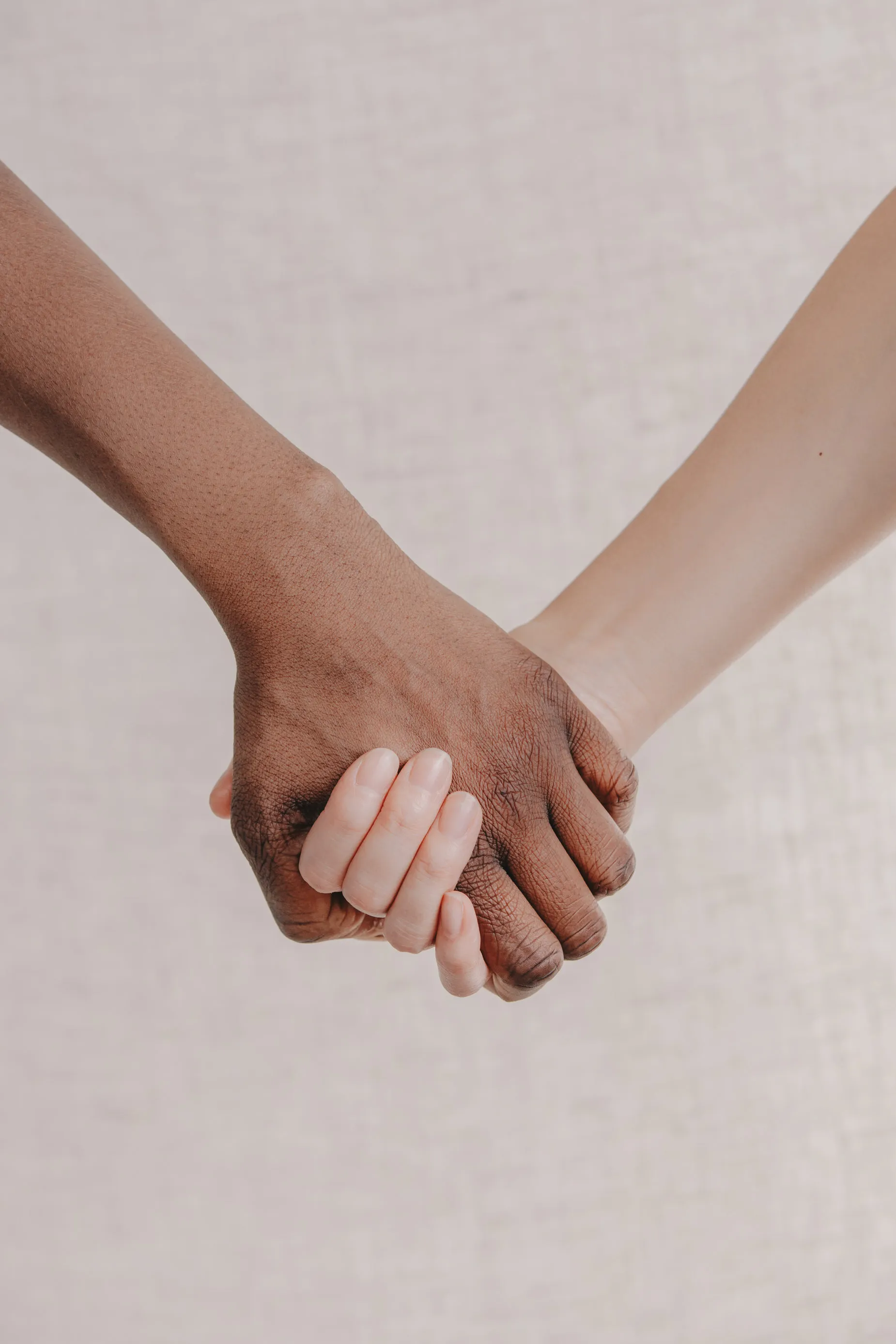 Two hands holding each other gently, representing emotional support.