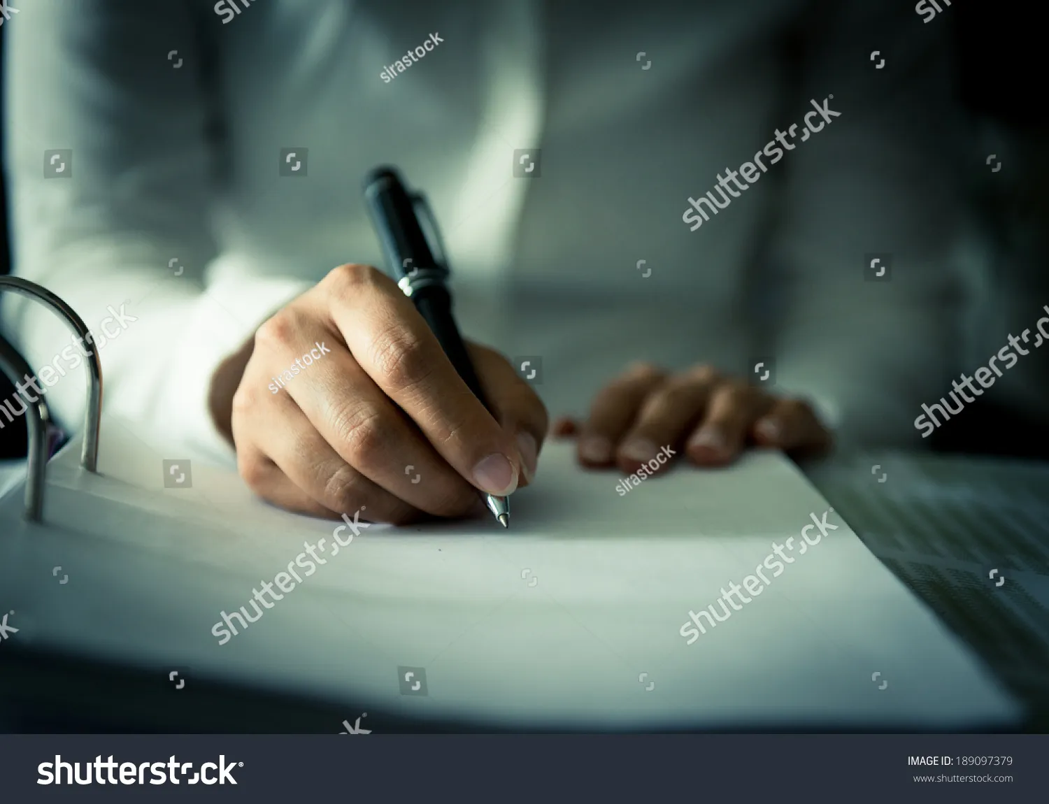 Close-up of a person writing a thoughtful sympathy message in a card.