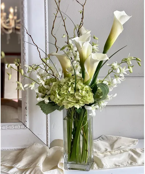 A small, tasteful bouquet of flowers placed on an office desk as a gesture of sympathy.