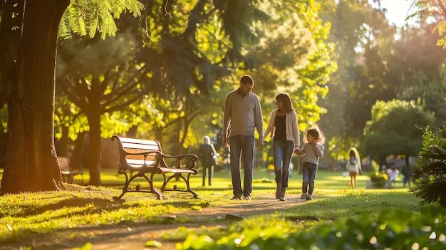 A family smiling while walking through a quiet, sunny park pathway.